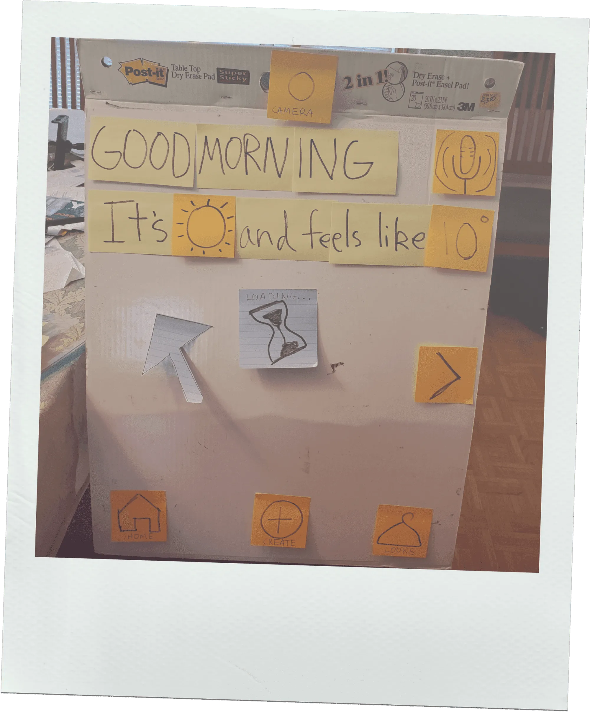 A life-sized paper prototype built on a Post-it easel, showing a good-morning greeting, the weather, and navigation icons